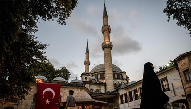 A Turkish national flag is seen on Eyup Sultan Mosque in Eyup district in Istanbul. Tourist arrivals in Turkey fell 40.86% year-on-year in June.