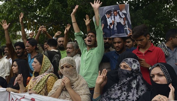 Relatives and area residents carry photographs of Pakistani national Zulfiqar Ali, who was sentenced to death in 2005 for heroin possession in Indonesia, during a protest in Lahore.