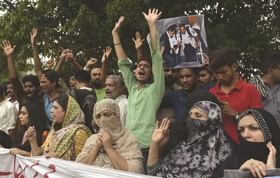 Relatives and area residents carry photographs of Pakistani national Zulfiqar Ali, who was sentenced to death in 2005 for heroin possession in Indonesia, during a protest in Lahore yesterday.