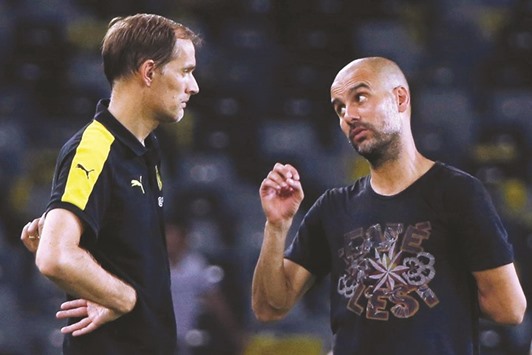 Manchester City manager Pep Guardiola talks to Dortmund coach Thomas Tuchel at the end of the match.