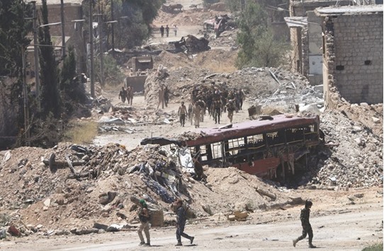 Syrian army soldiers patrol the area around the entrance of Bani Zeid after taking control of the previously rebel-held district of Leramun, on the northwest outskirts of Aleppo.