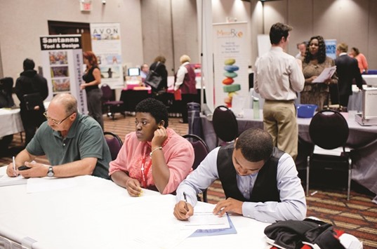 Job seekers fill out job applications during a career fair in Sterling Heights, Michigan. Initial claims for state unemployment benefits increased 14,000 to a seasonally adjusted 266,000 for the week ended July 23, the Labour Department said yesterday.