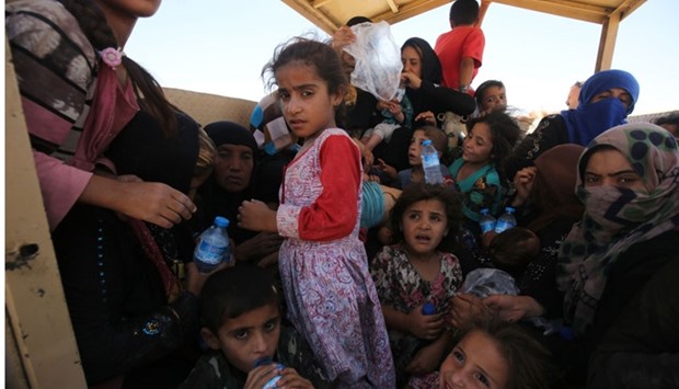 Iraqi women and children who fled the towns of al-Shirqat and Qayyarah during reported fighting between Iraqi government forces and jihadists of the Islamic State (IS) group, are transferred to a camp for displaced people on July 27, 2016. AFP