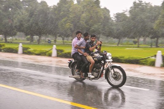 Motorcyclists during a monsoon downpour in New Delhi.