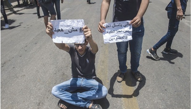 Egyptian students hold placards during a demonstration against the education minister and the education system outside the Ministry of Education in the capital Cairo on June 27, 2016. The writing in Arabic reads: u201cI will no repeatu201d, u201cFor those asking who we are, we are the wronged studentsu201d.  Answers to final exams had been leaked anonymously on Facebook.