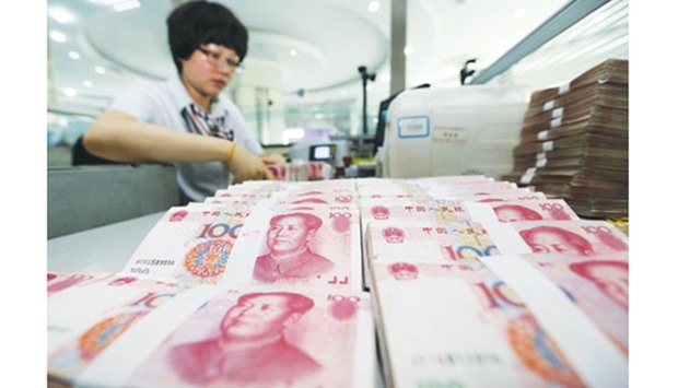 A teller counts yuan notes in a bank in Lianyungang, China. The Peopleu2019s Bank of China has signalled that it wants to avoid a pile up of one-way bets on the currency.