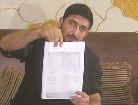 Mukhtar Kazam displaying the post-mortem report of his dead wife during a press conference in Rawalpindi.