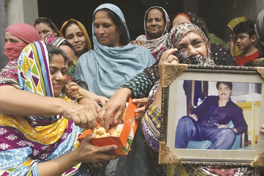 Relatives of Pakistani national, Zulfiqar Ali, who was convicted to death in 2005 for heroin possession, share sweets in celebration after the Indonesian government halted his execution, in Lahore yesterday.