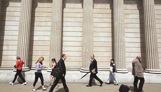 Pedestrians walk past the Bank of England in the City of London. The BoE is moving to reassure investors that even a recession, and the potential impact on earnings and asset prices, wonu2019t put them at risk of breaching minimum capital levels.