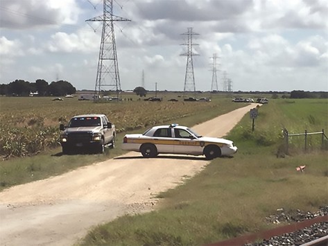 This handout photograph obtained courtesy of KXAN TV shows a police vehicle blocking a road where a hot air balloon crashed near Lockhart, Texas.