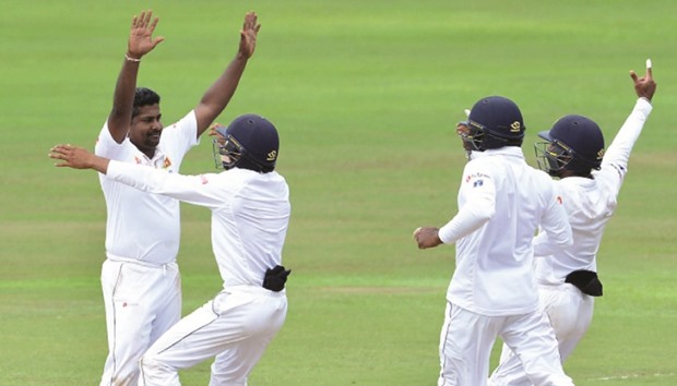 Sri Lankau2019s Rangana Herath (left) celebrates the wicket of Australiau2019s Steve Ou2019Keefe with his teammates on the fifth day of the first Test in Pallekele yesterday.