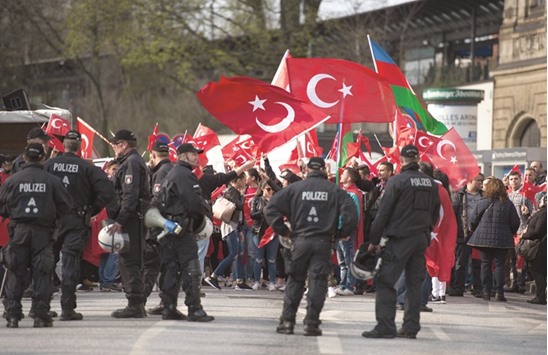 This file photo taken on April 10 shows police watching protesters during a u2018Peace March for Turkeyu2019 organised by the new German Turkish Committee in Hamburg. Tens of thousands of supporters of Turkish President Recep Tayyip Erdogan plan to rally in the German city of Cologne today as tensions over Turkeyu2019s failed coup have put authorities on edge.