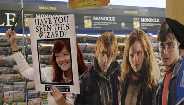A fan poses for photograph next to a poster during the launch of the new book 'Harry Potter and the Cursed Child' at a book store in Singapore on Sunday.