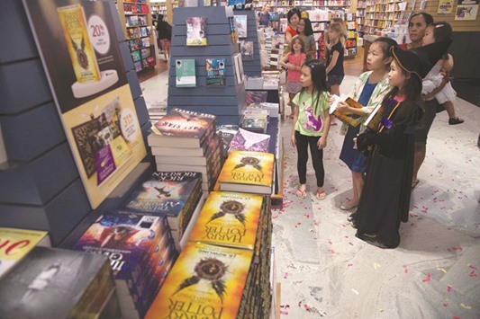 Children watch a video preview at a book store during the launch of the new book Harry Potter and the Cursed Child in Singapore yesterday.