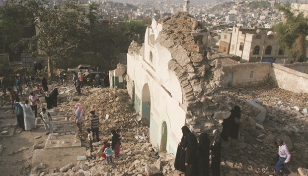 People gather among the rubble of a Sufi mosque that was blown up by explosive devices in an attack in the southwestern city of Taiz, on Saturday.