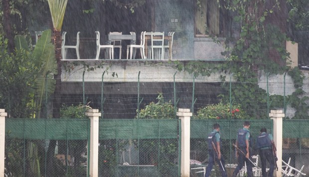 Policemen looking into the back garden of an upscale cafe in Dhaka yesterday a day after a bloody siege ended with the death of 20 foreign hostages.