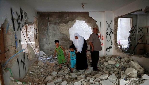 The parents of Palestinian assailant Essa Assaf inspect their family house it was partially destroyed by Israeli troops on Monday, in Qalandia refugee camp near the West Bank city of Ramallah.