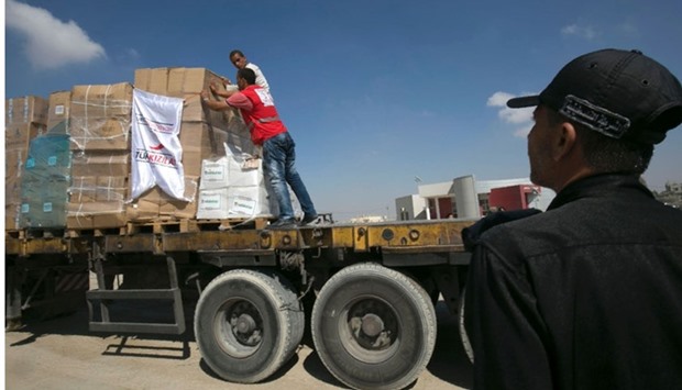 Workers stand on a truck loaded with aid parcels provided by Turkey after it entered the southern Gaza Strip from Israel through the Kerem Shalom crossing near Rafah.