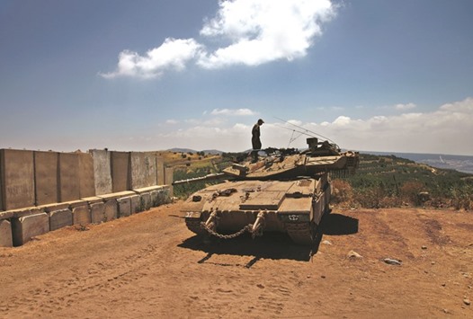 An Israeli tank takes position near the Israel-Syria border in the Israeli-annexed Golan Heights yesterday, the day after the Israeli army attacked two Syrian military targets on the Golan Heights.