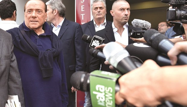 Berlusconi talks with reporters as he leaves the hospital in Milan, where he checked into on June 7 with symptoms of heart failure. He underwent open-heart surgery at the hospital.