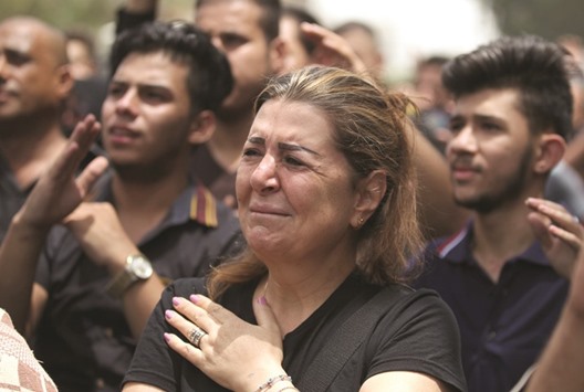 An Iraqi Christian woman reacts yesterday, as people gather at the site of a suicide-bombing attack which took on July 3 in Baghdadu2019s Karrada neighbourhood. The bombing claimed by the Islamic State group killed at least 250 people, officials said yesterday, raising the toll of what was already one of the deadliest attacks in Iraq.