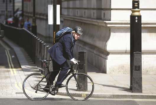 Conservative party MP, Boris Johnson, rides his bike along Whitehall in London yesterday.