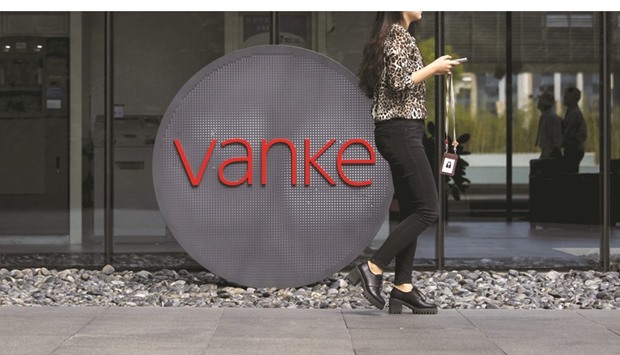 An employee walks past a logo of Vanke at its headquarters in Shenzhen, Guangdong province. The Chinese firmu2019s largest shareholder Baoneng built up a holding of about 24% in Vanke last year.