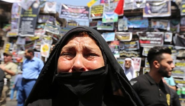 An Iraqi woman cries in front of a memorial for the victims of a bombing which claimed the lives of 292 people in Baghdad's Karrada neighbourhood.