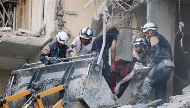 Syrian emergency personnel remove the body of a man from the rubble of a damaged building following reported air strikes in Aleppo's rebel-held neighbourhood of Tariq al-Bab.