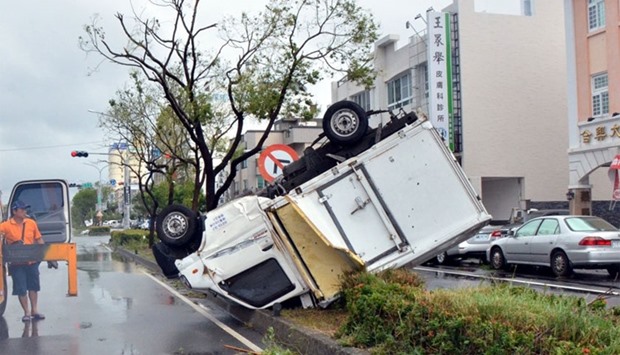 A truck sits on a traffic divider after being blown over by strong winds in the Taiwanese city of Taitung on July 8, 2016 after Super Typhoon Nepartak passed over the island.