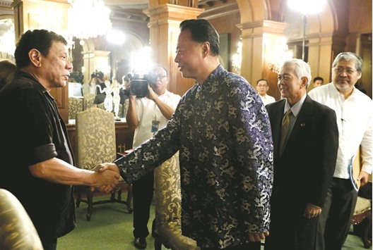 President Rodrigo Duterte shaking hands with Chinese ambassador to the Philippines Zhao Jianhua during his courtesy call to the Malacanang palace in Manila.