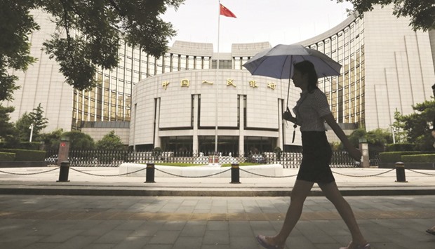 A pedestrian walks past the Peopleu2019s Bank of China in Beijing. Chinau2019s central bank has increasingly relied on medium term lending facility loans to guide medium-term interest rates and manage liquidity in the banking system, sources with direct knowledge of the matter said yesterday.