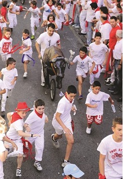 Children run during the u2018encierro txikiu2019 (small bull run) of the San Fermin Festival in Pamplona  yesterday.