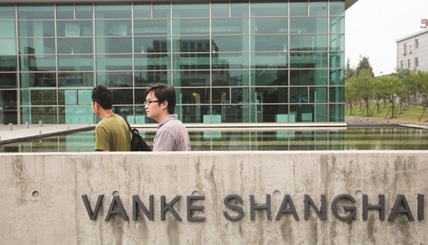 People walk in front of China Vanke Co headquarters in Shanghai. One of Chinau2019s top-ranked hedge fund managers turned to social media as he sought to borrow shares for a bearish wager against China Vanke, the developer embroiled in a struggle for control with major shareholders.