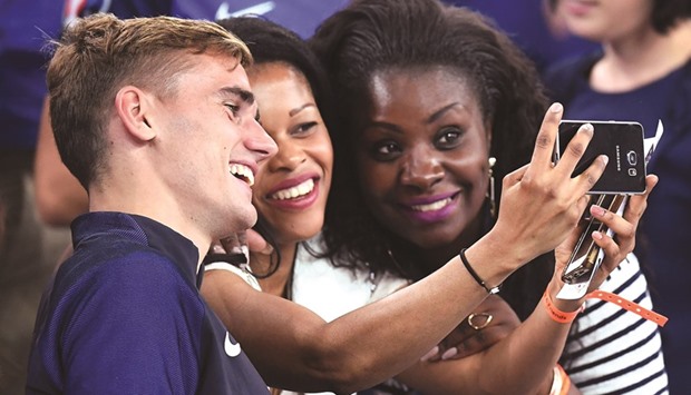 France forward Antoine Griezmann (left), who scored both goals for France in the hostsu2019 2-0 win over Germany in the Euro 2016 semi-final on Thursday, poses for a photograph with fans. (AFP)