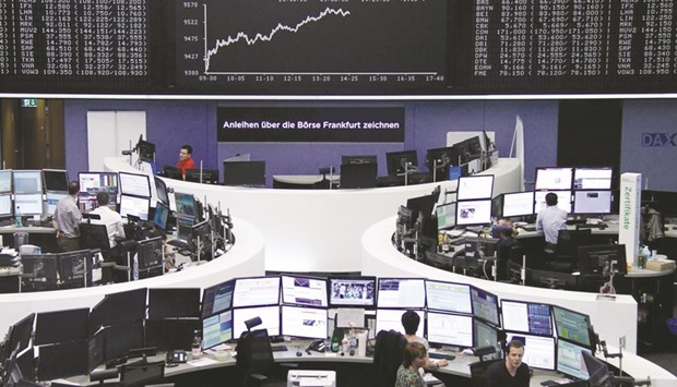 Traders work at the Frankfurt Stock Exchange. The DAX 30 closed up 1.9% to 9,598.55 points yesterday.