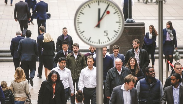 Pedestrians walk past clocks in the Canary Wharf business, financial and shopping district of London. British consumer confidence suffered one of its biggest drops in 21 years and the countryu2019s largest department store expressed concern over the poundu2019s fall, in the strongest evidence to date of the challenges Britainu2019s economy faces after the Brexit vote.