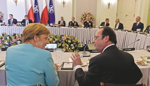 German Chancellor Angela Merkel  and French President Francois Hollande chat during a working dinner at the Presidential Palace in Warsaw yesterday.