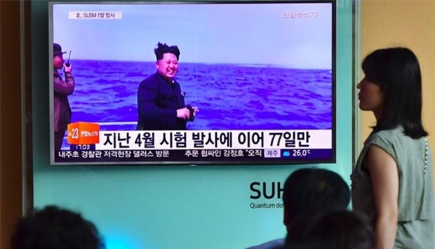 People watch a television news broadcast at a railway station in Seoul on Saturday, showing file footage of North Korea's leader Kim Jong Un during a missile launch.
