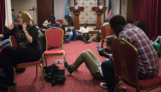 Journalists sit inside the conference room as artillery fire broke out near the presidential palace in Juba, yesterday.