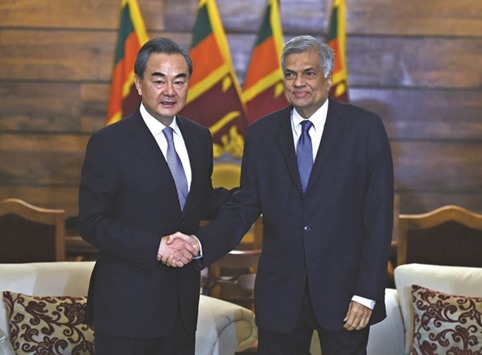 Chinese Foreign Minister Wang Yi, left, shaking hands with Sri Lankau2019s Prime Minister Ranil Wickremesinghe ahead of a meeting in Colombo yesterday.