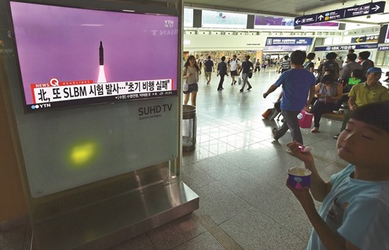 People walk past a television screen at a railway station in Seoul yesterday, showing file footage of a North Korean missile launch.