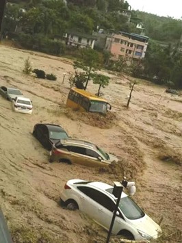 This image taken with a cameraphone shows cars and buses  being washed away yesterday by floodwaters in Fuzhou, in  eastern Chinau2019s Fujian province.