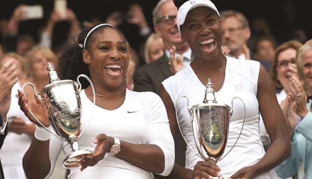 USAu2019s Serena Williams and Venus Williams pose with their trophies after winning the doubles against Hungaryu2019s Timea Babos and Kazakhstanu2019s Yaroslava Shvedova.
