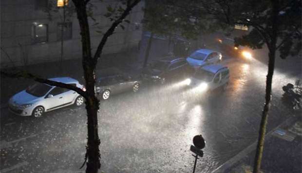 A motorist drives a vehicle during heavy rain in Paris on Sunday.