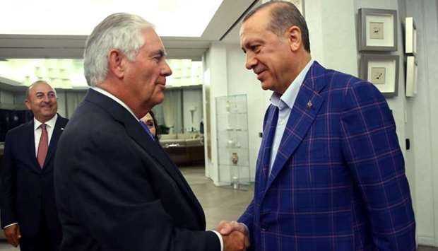 Turkish President Recep Tayyip Erdogan and US Secretary of State Rex Tillerson shake hands within their meeting in Istanbul, as Turkey's Foreign Minister Mevlut Cavusoglu looks on.
