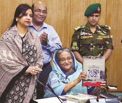 Prime Minister Sheikh Hasina unveiling 1971 commemorative postage stamps and the First Day Covers with photos of genocide and war crimes of the Pakistani army and their local collaborators yesterday. On her right is Tarana Halim, state minister of the post and telecommunications division.