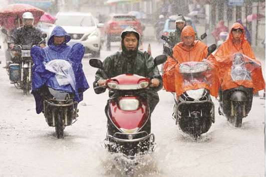 People ride motorcycles under heavy rain in Rongu2019an County, Guangxi Zhuang Autonomous Region, China.