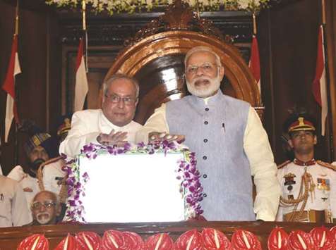 President Pranab Mukherjee rolls-out the Goods and Services Tax in Parliamentu2019s Central Hall as Prime Minister Narendra Modi looks on.