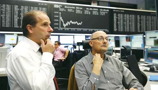 Traders work at the Frankfurt Stock Exchange. The DAX 30 closed up 1.5% to 12,626.58 points yesterday.